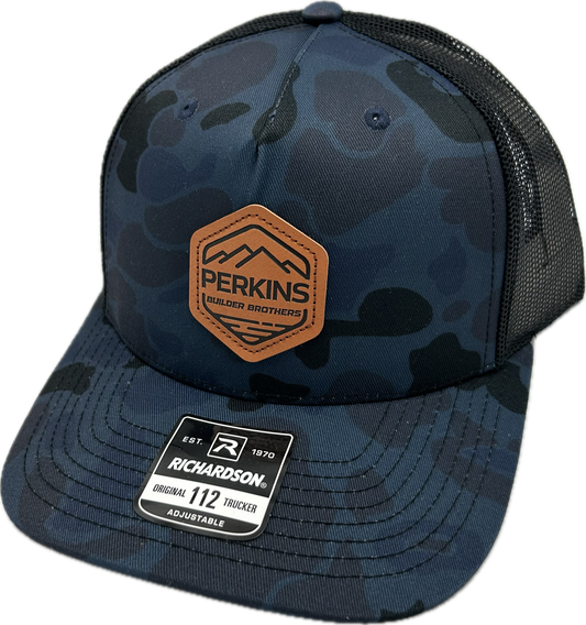 Genuine Leather Patch - Richardson 112PFP Snapback Trucker Hat - Admiral Duck Camo/Black - Perkins Builder Brothers